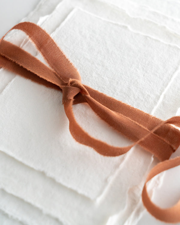 Tono + co Silk Ribbon Trim in Copper. Perfect for stationary styling, boutonnieres, and detail work. Find your inspiration through color and silk. Lovingly hand-dyed in Santa Ana, California and available in 24 signature colors. Check out our website for more styling, flat-lay, and color tips.